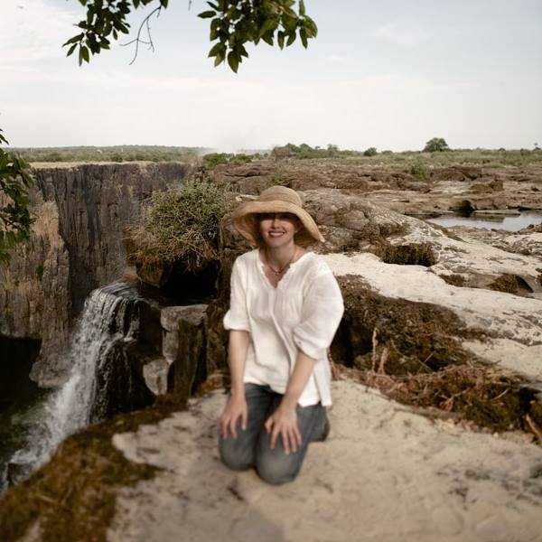 Annelize Bester sitting on the edge of Zambia's Victoria Falls